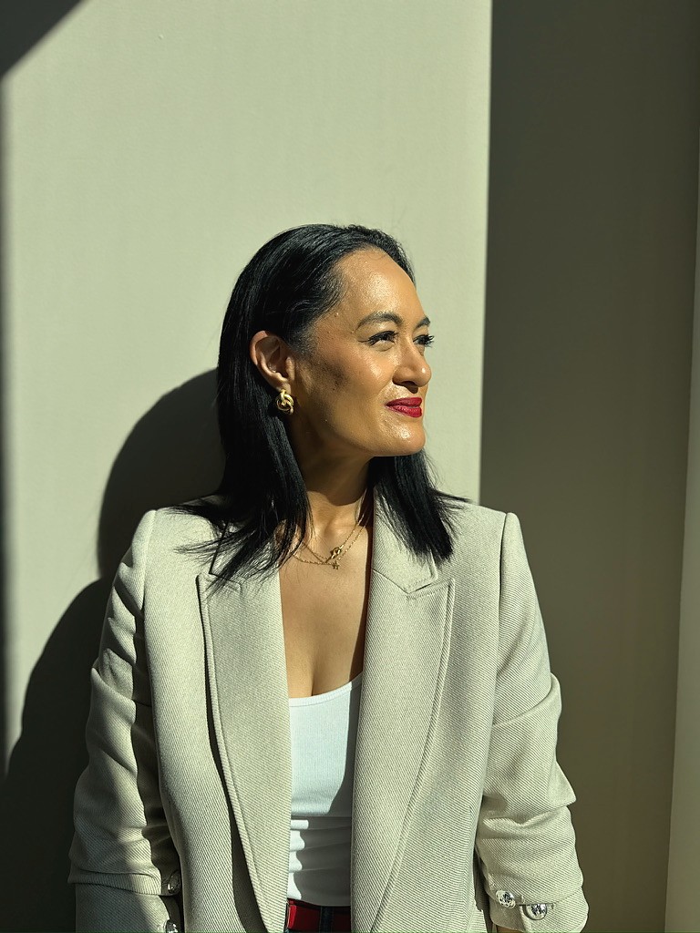 Anne Maxwell in a sage blazer, looking toward the light